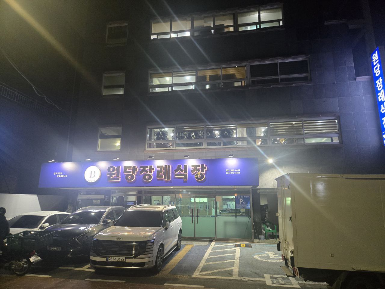 밤에 촬영된 원당장례식장 외부 입구와 주차장