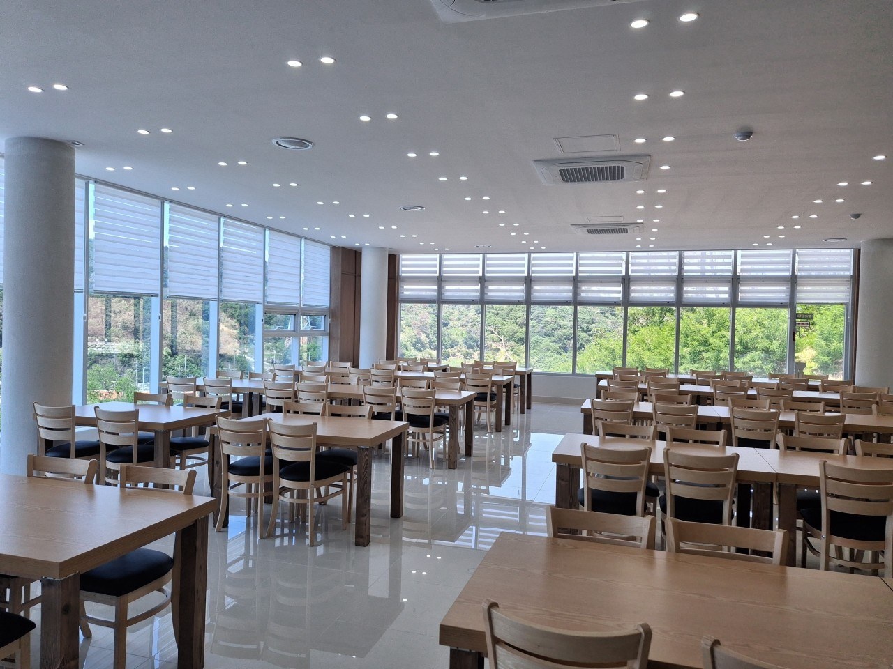 큰 창과 여러 좌석이 마련된 밝은 식당 내부