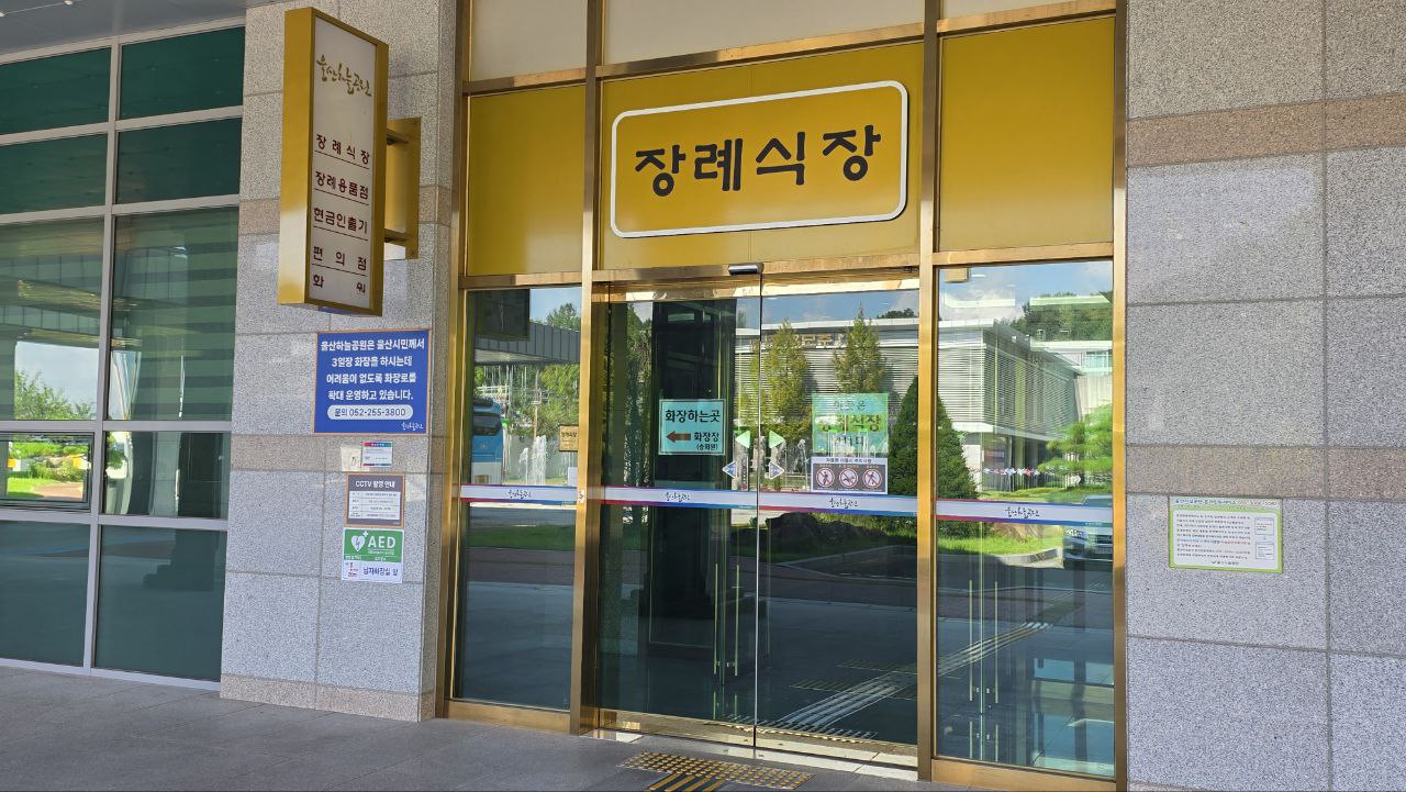 유리문과 노란색 장례식장 표지판이 보임